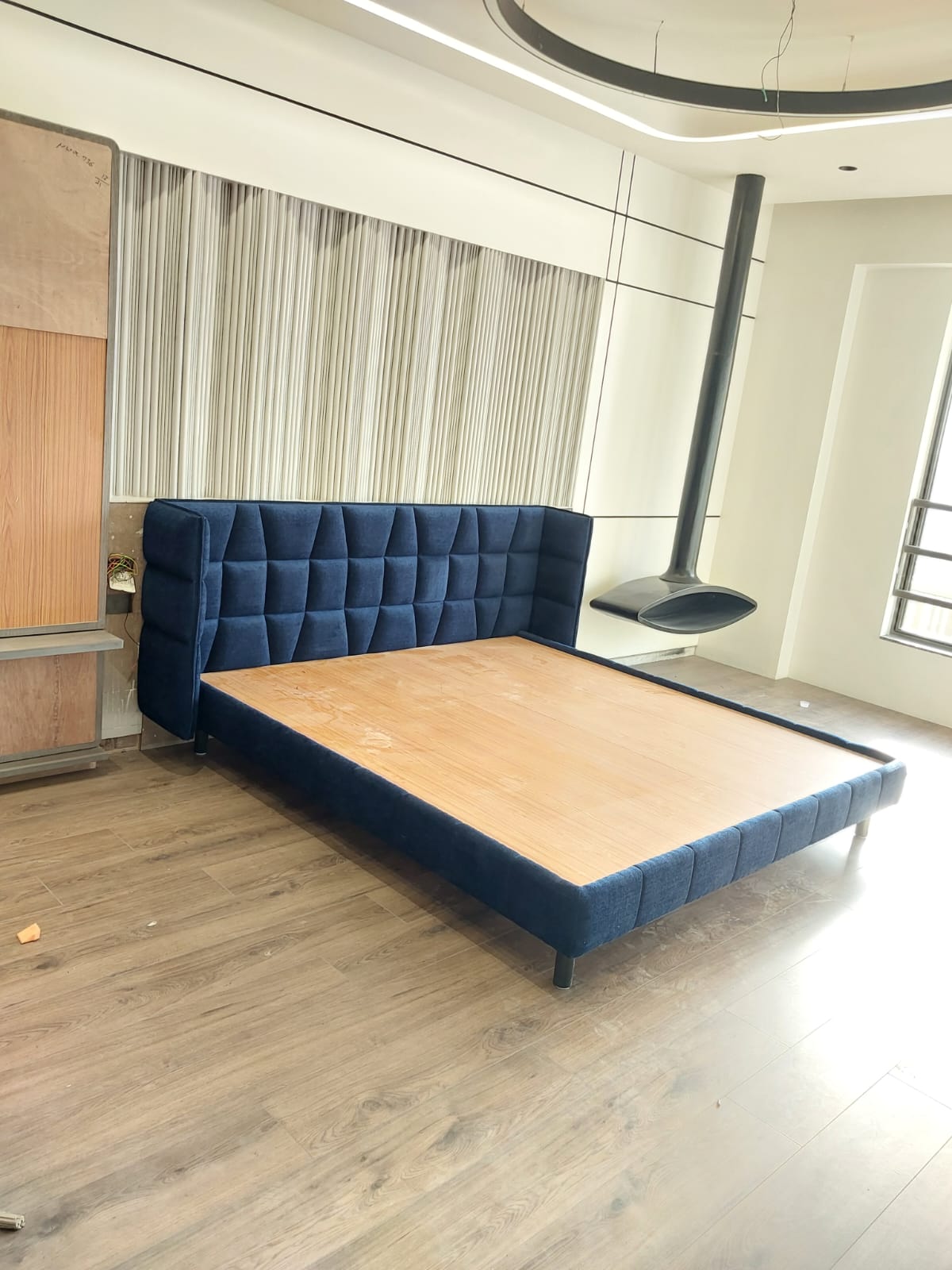 Navy blue grid-tufted bed with walnut platform