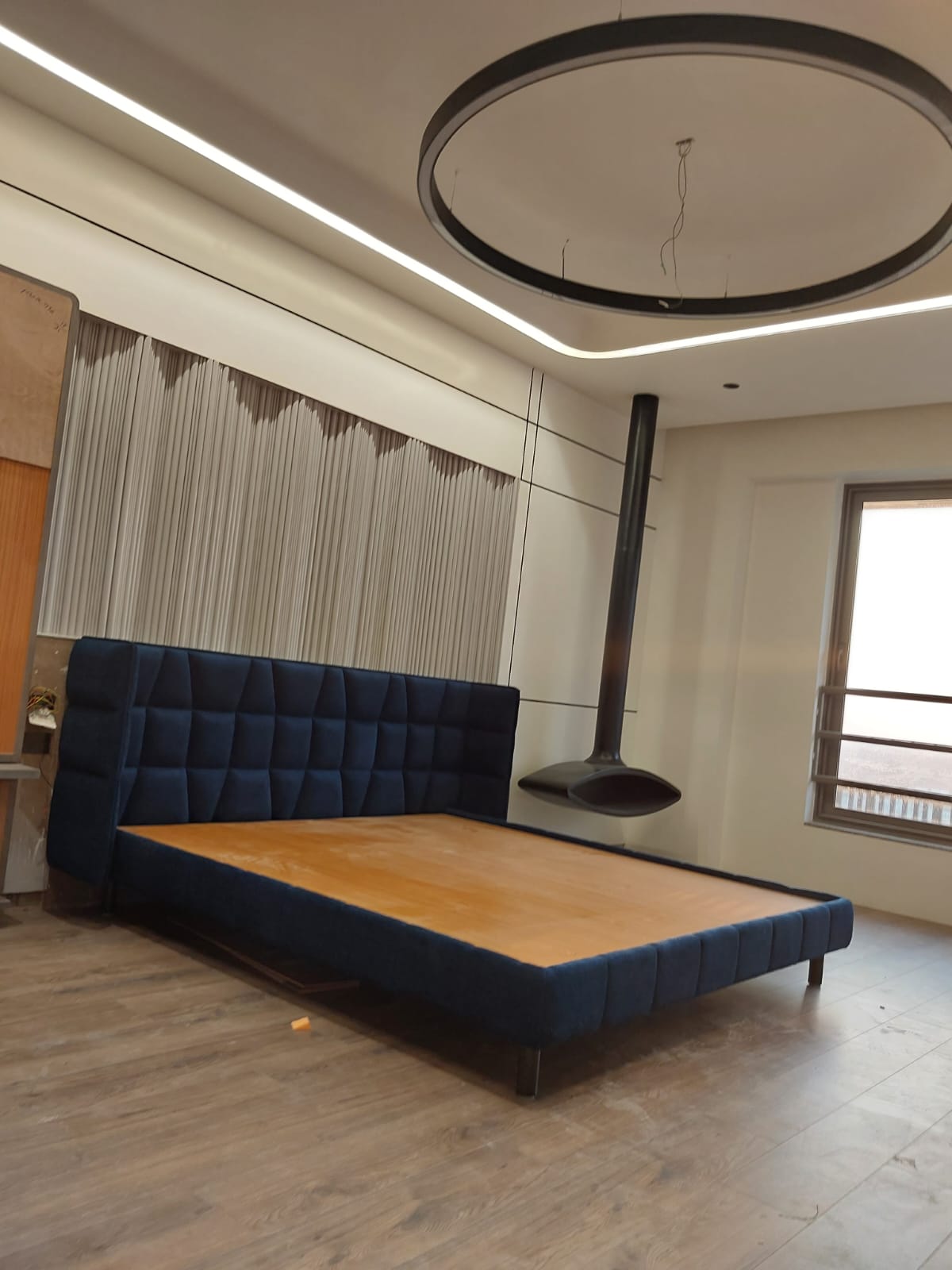 Midnight blue tufted headboard with round pendant
