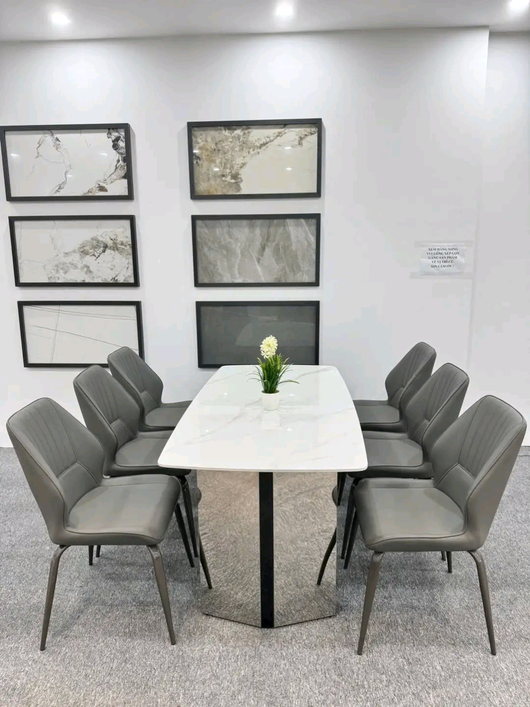 White stone table with 8 slate-grey leather chairs