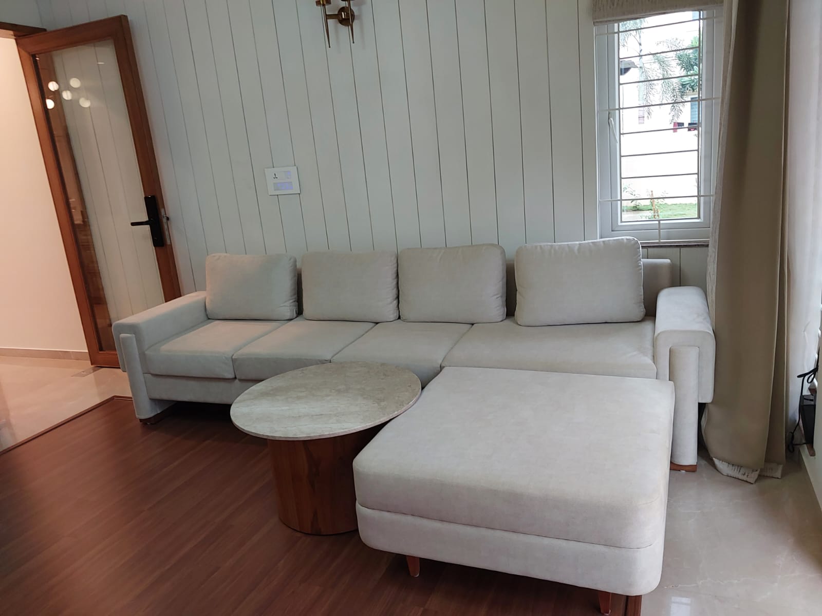 Cream chaise sectional with round walnut table