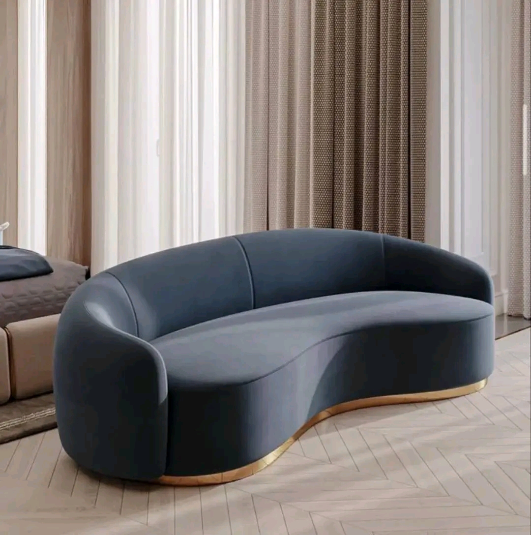 Navy velvet curved sofa with brushed-gold base trim