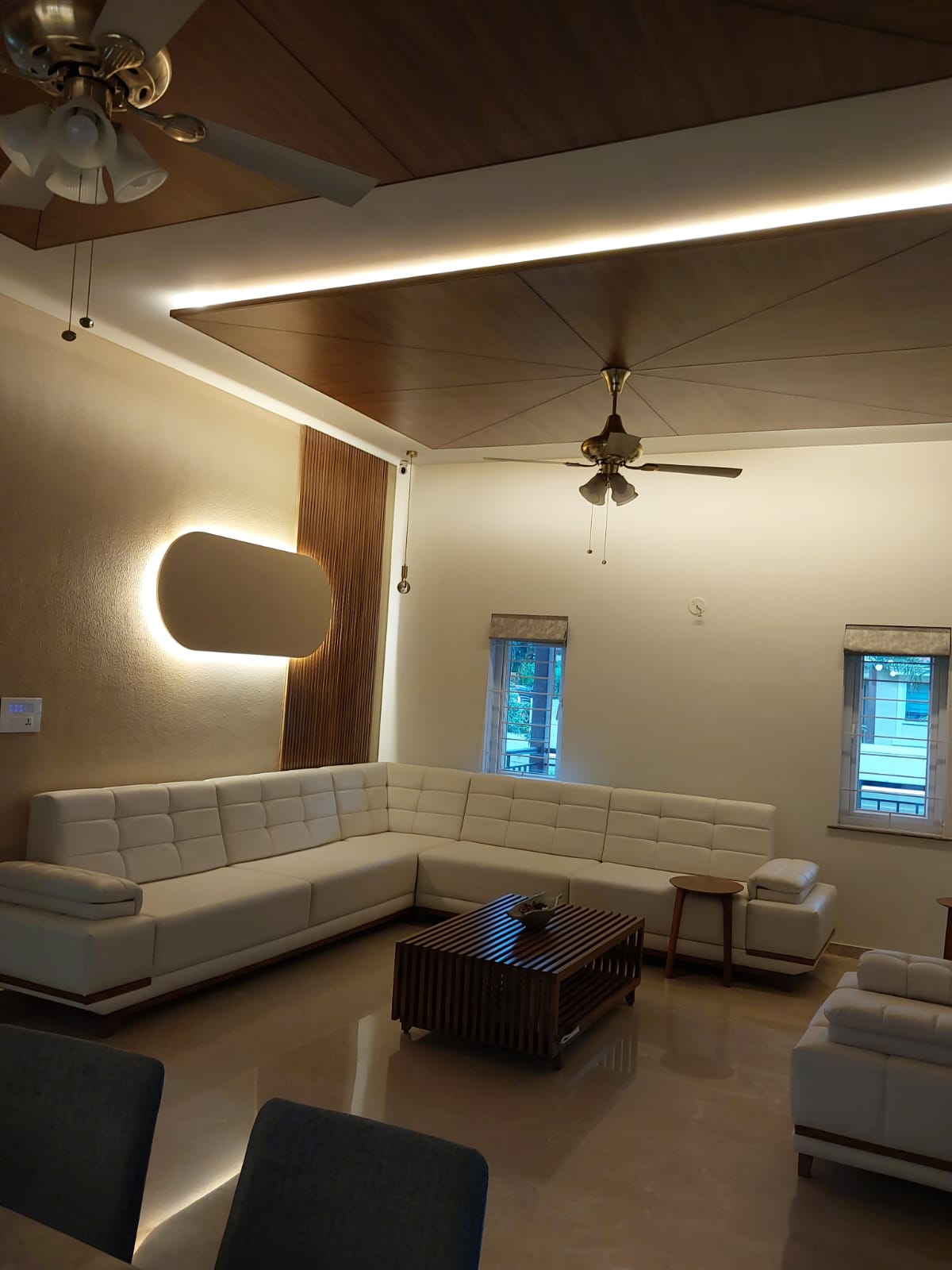 White L-sofa in warm chandelier-lit living room